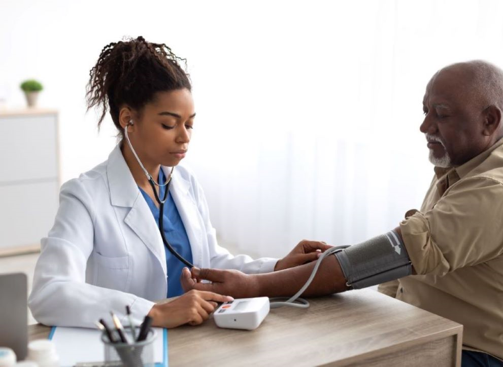 A doctor takes a blood pressure reading from a patient.