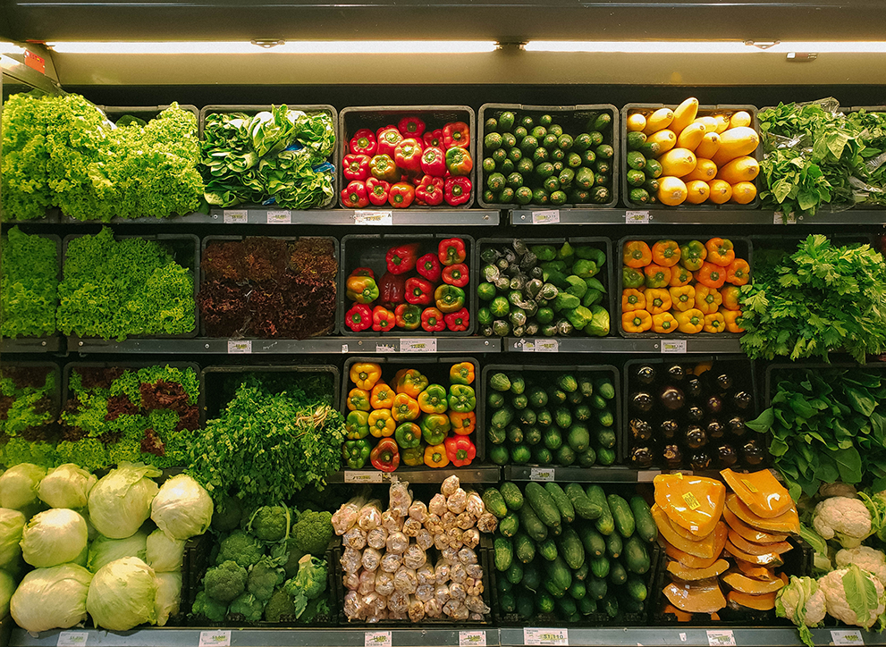 Fresh vegetables on grocery store shelves.