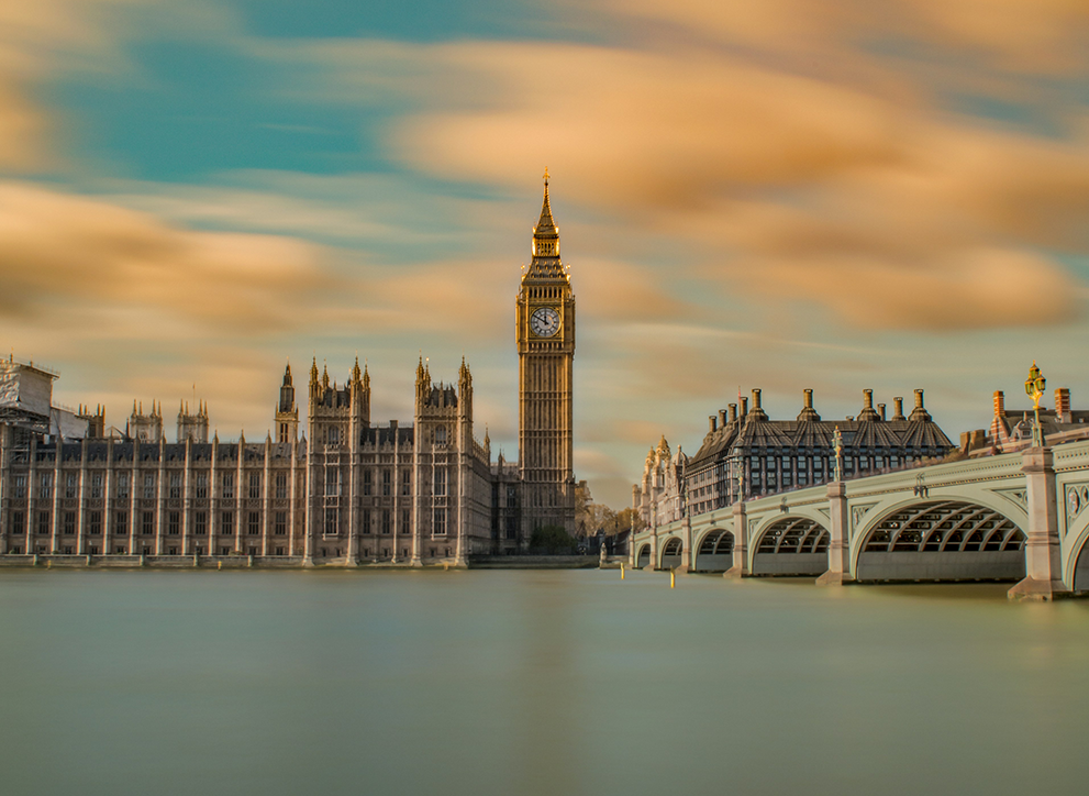 Long exposure photo of the UK Houses of Parliament and Portcullis House, taken from across the River Thames.