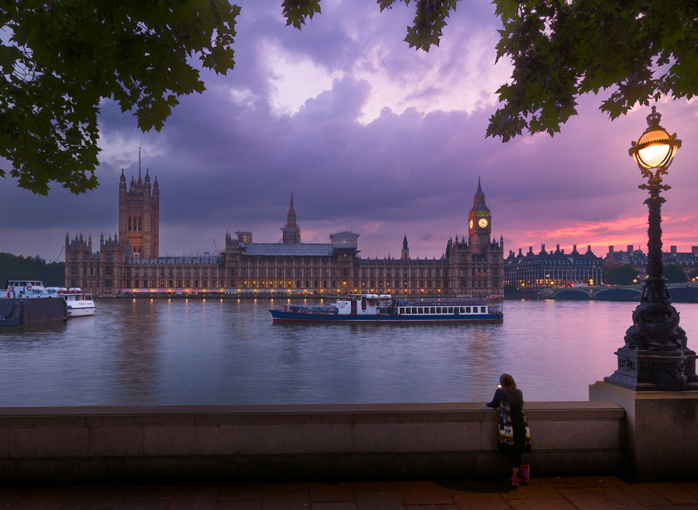 Photo of the UK Houses of Parliament at dusk, taken from across the River Thames.